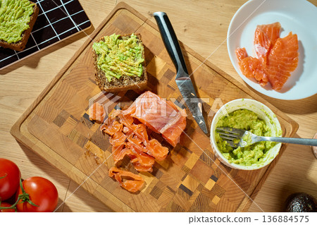 Smoked salmon, avocado toast and guacamole on wooden cutting board Smoked salmon, avocado toast and guacamole on wooden cutting board 136884575