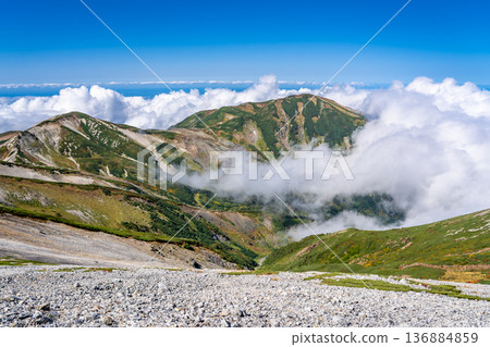 View of Mt. Yukikura and Mt. Hachigatake from Mt. Korenge. Traverse from Hakuba-Oike to Mt. Hakuba in the Northern Alps. View of Mt. Yukikura and Mt. Hachigatake from Mt. Korenge. Traverse from Hakuba-Oike to Mt. Hakuba in the Northern Alps. 136884859
