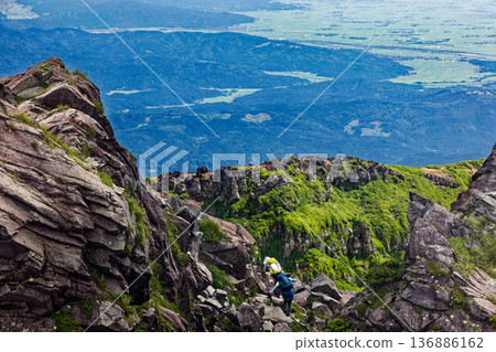 Climbers climbing to the summit of Mt. Chokai's Shinzan mountain and the view of the outer rim ridge and Shonai Plain 136886162