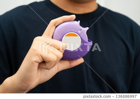 Asthma and chronic obstructive pulmonary disease COPD, Asian young man using metered dose inhaler MDI. 136886997