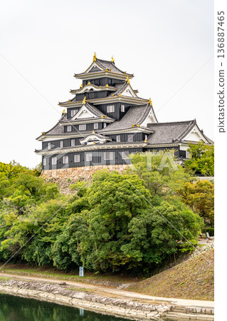 Okayama Castle (a nationally designated historic site, also known as Crow Castle or Golden Crow Castle) seen from Tsukimi Bridge in Korakuen Garden. The castle tower (restored exterior) Okayama Castle (a nationally designated historic site, also known as Crow Castle or Golden Crow Castle) seen from Tsukimi Bridge in Korakuen Garden. The castle tower (restored exterior) 136887465