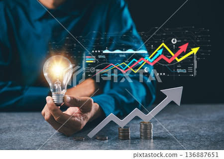 Business idea growth concept solution marketing shown within lightbulb, hand holds bulb with creative financial strategy using digital data charts and coin stacks for light ideas Business idea growth concept solution marketing shown within lightbulb, hand holds bulb with creative financial strategy using digital data charts and coin stacks for light ideas 136887651