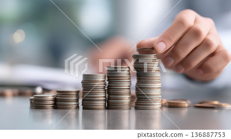 Person is putting coins on top of each other 136887753