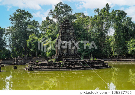 Ancient stone tower of neak pean island temple standing in middle of green pond water in angkor wat complex cambodia Ancient stone tower of neak pean island temple standing in middle of green pond water in angkor wat complex cambodia 136887795