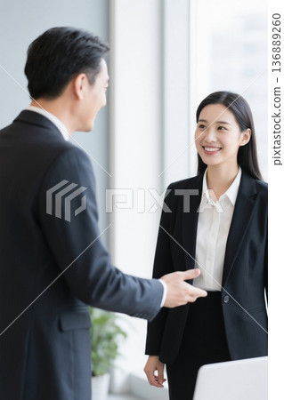 办公室里两位职场人士交谈 136889260