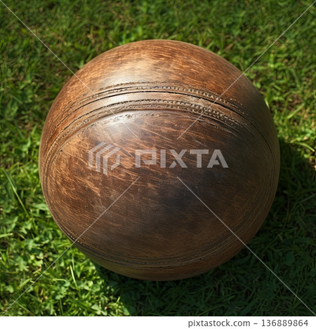 Vintage Brown Leather Ball on Green Grass Nostalgic Sports Equipment for Recreation. Vintage Brown Leather Ball on Green Grass Nostalgic Sports Equipment for Recreation. 136889864