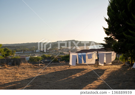 Clothes Hanging on a Line Under the Setting Sun Near the Coast in a Tranquil Landscape With Distant Hills Clothes Hanging on a Line Under the Setting Sun Near the Coast in a Tranquil Landscape With Distant Hills 136889939