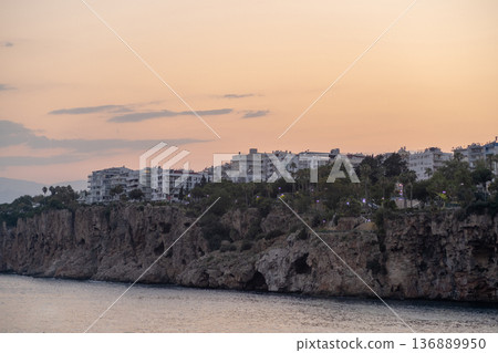 Coastal Sunset View of Rocky Cliffs and Residential Buildings in Antalya During the Evening Hours 136889950