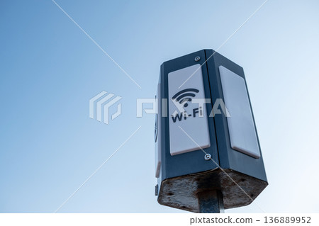 Public Wi-Fi Hotspot Installed on a Metal Pole Against a Clear Sky in an Urban Area Providing Internet Access for Nearby Users Public Wi-Fi Hotspot Installed on a Metal Pole Against a Clear Sky in an Urban Area Providing Internet Access for Nearby Users 136889952