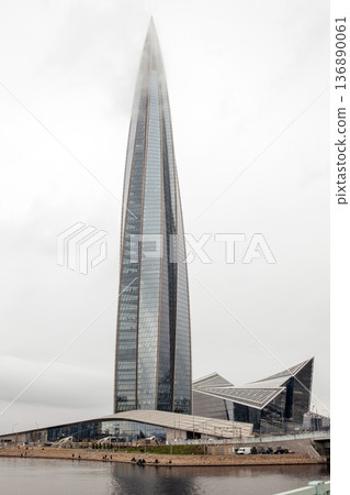 Imposing View of Lakhta Center Rising Above the Waterfront in Saint Petersburg Amidst a Cloudy Sky 136890061