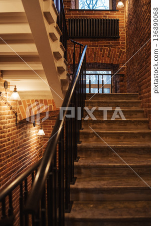 Elegant Staircase With Brick Walls and Warm Lighting in a Cozy Building During the Evening Elegant Staircase With Brick Walls and Warm Lighting in a Cozy Building During the Evening 136890068