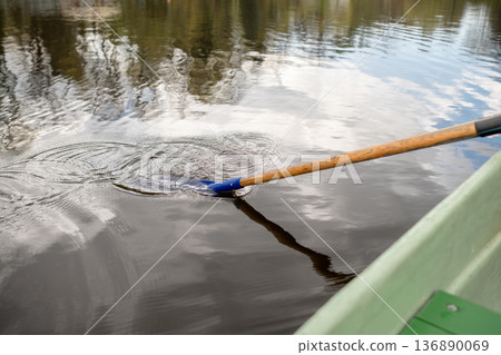 Rowing a Boat on a Calm Lake With Reflections of Trees Under a Cloudy Sky Rowing a Boat on a Calm Lake With Reflections of Trees Under a Cloudy Sky 136890069