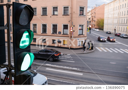 Traffic Light Showing Green at an Urban Intersection During Late Afternoon With Pedestrians and Vehicles in the Vicinity Traffic Light Showing Green at an Urban Intersection During Late Afternoon With Pedestrians and Vehicles in the Vicinity 136890075