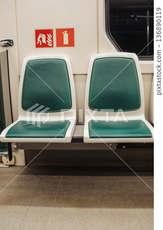 Empty Green and White Seats on a Subway Train in a Urban Transit System at Night Empty Green and White Seats on a Subway Train in a Urban Transit System at Night 136890119