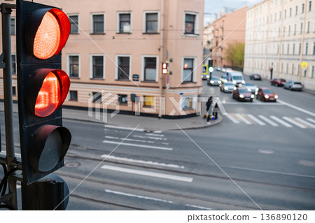 Red Traffic Light Signals Vehicles to Stop at Urban Intersection During Late Afternoon in a City Setting 136890120