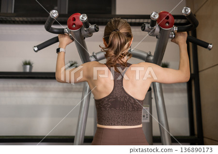 Fitness Enthusiast Performing a Strength Training Exercise in a Modern Gym Environment During Daytime Fitness Enthusiast Performing a Strength Training Exercise in a Modern Gym Environment During Daytime 136890173