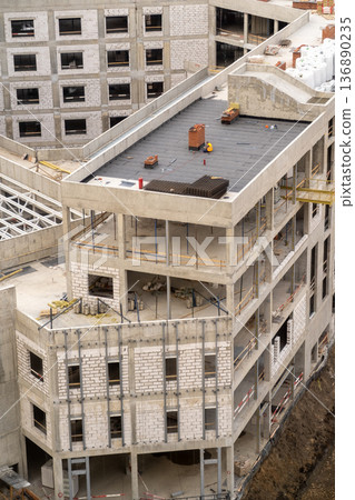 New Commercial Building Under Construction With Modern Architecture Details and Ongoing Worksite Activity in a Bustling Urban Area 136890235