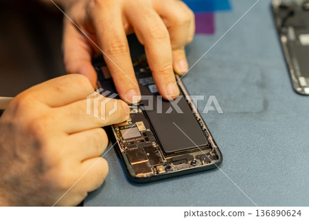 Phone Repair Technician Fixing a Smartphones Internal Components in a Workshop 136890624