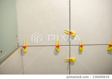 Installation of Tile Leveling Clips on a Construction Wall in a Home Renovation Project During Daytime Installation of Tile Leveling Clips on a Construction Wall in a Home Renovation Project During Daytime 136890639