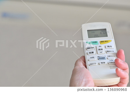 Senior woman operating the air conditioner 136890968