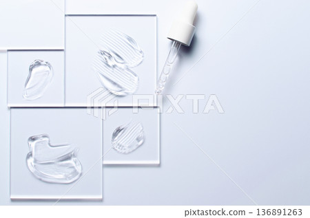 A sample of a transparent cosmetic skin care product on glass. Blue background A sample of a transparent cosmetic skin care product on glass. Blue background 136891263