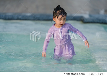 preschool child girl playing and swimming in pool 136891390