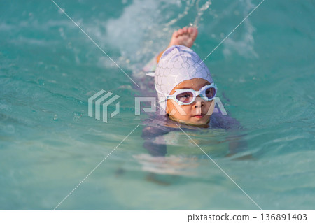 preschool child girl playing and swimming in pool 136891403