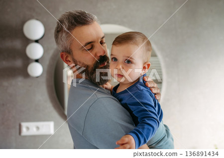 Morning routine in bathroom, father preparing baby for day. 136891434