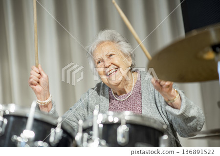 Senior woman enjoying her hobby playing drums. 136891522