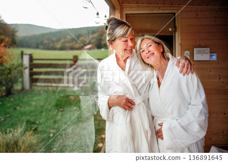 Two older friends enjoying sauna session and wellness ritual. Two older friends enjoying sauna session and wellness ritual. 136891645