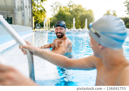 Father and teenage son enjoying swim training together. 136891755