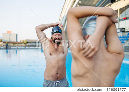 Father and teenage son preparing for swim training, stretching. Father and teenage son preparing for swim training, stretching. 136891777