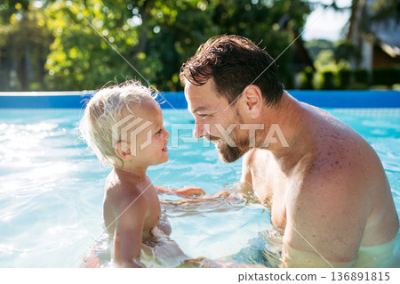 Father playing with little son in pool. 136891815