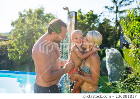 Family under shower by the pool on sunny summer day. Family under shower by the pool on sunny summer day. 136891817