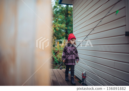 Girl going on fishing trip, wearing rubber boots. 136891882