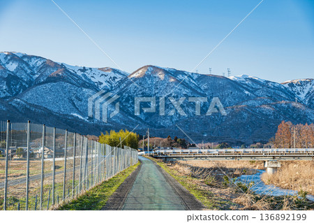 Chiuchi River in early spring and the Nosaka Mountains with remaining snow. Makino Town, Takashima City, Shiga Prefecture Chiuchi River in early spring and the Nosaka Mountains with remaining snow. Makino Town, Takashima City, Shiga Prefecture 136892199