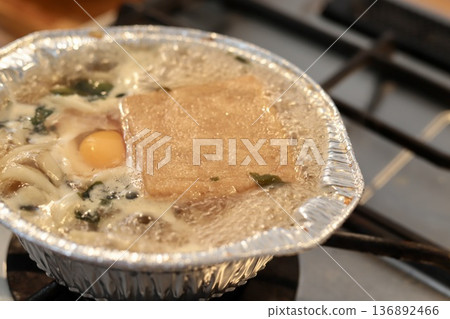 Nabeyaki udon noodles being boiled in an aluminum pot 136892466
