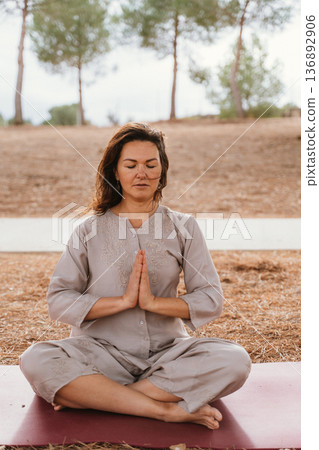 Woman Meditating Outdoors in Peaceful Setting Woman Meditating Outdoors in Peaceful Setting 136892906
