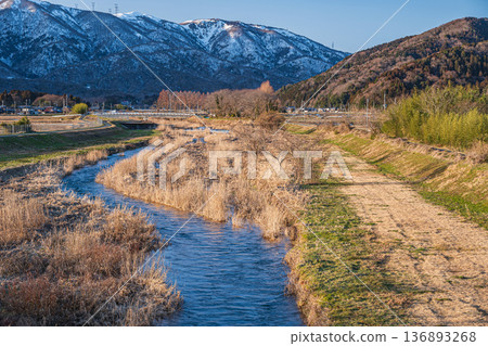 Chiuchi River in early spring and the Nosaka Mountains with remaining snow. Makino Town, Takashima City, Shiga Prefecture Chiuchi River in early spring and the Nosaka Mountains with remaining snow. Makino Town, Takashima City, Shiga Prefecture 136893268