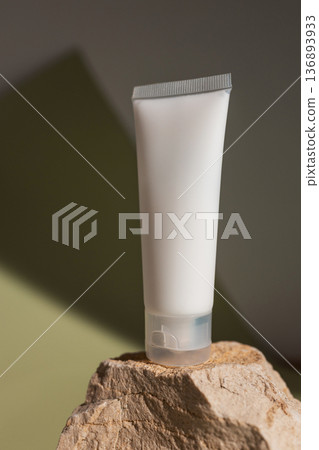 Minimal beauty product mockup with blank cosmetic tube standing on natural stone, styled with warm light and earthy tones for organic skincare, modern branding and clean cosmetic packaging design. 136893933