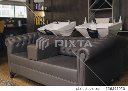 Modern barbershop interior with shampoo wash stations and styling area. Professional salon workspace, clean grooming environment, contemporary design, barber service concept. 136893950