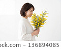 Profile of a woman with a bouquet of mimosa 136894085