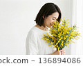 Profile of a woman with a bouquet of mimosa 136894086