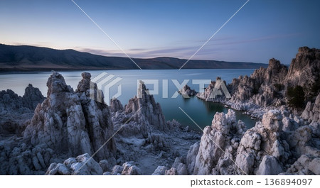 Limestone tufa towers at lake in twilight with clear air from a cliff edge 136894097