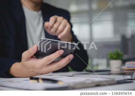 Businessman hand use calculator calculate data. Financial accounting concept. Man work office desk, planning budget, analyze report document. Investment savings economy tax calculation, data analysis. Businessman hand use calculator calculate data. Financial accounting concept. Man work office desk, planning budget, analyze report document. Investment savings economy tax calculation, data analysis. 136895654