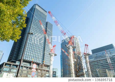 Tower cranes constructing buildings in the redevelopment of Tokyo's Marunouchi district, construction in progress in the high-rise building district Tower cranes constructing buildings in the redevelopment of Tokyo's Marunouchi district, construction in progress in the high-rise building district 136895718