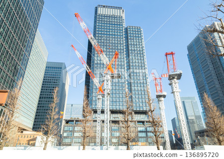 Tower cranes constructing buildings in the redevelopment of Tokyo's Marunouchi district, construction in progress in the high-rise building district 136895720