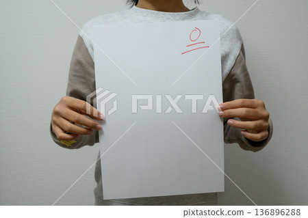Torso of a child holding a test paper with a score of 0 Torso of a child holding a test paper with a score of 0 136896288