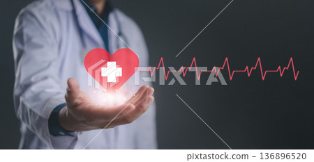 Doctor hand holding red heart icon with heartbeat pulse line. Cardiology care, medical service for health insurance, life support. Concept of donation, patient wellness, diagnosis and treatment. 136896520