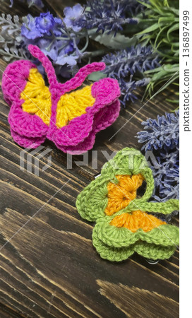 Butterflies made of colored yarn, crocheted on a dark surface. Handmade. 136897499